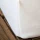 クラシック・ホワイト400TC／ボックスシーツ | Beaumont & Brown | 白いシンプルなボックスシーツをマットレスにかけた時の角の部分の写真、細かい部分も丁寧に仕上げています